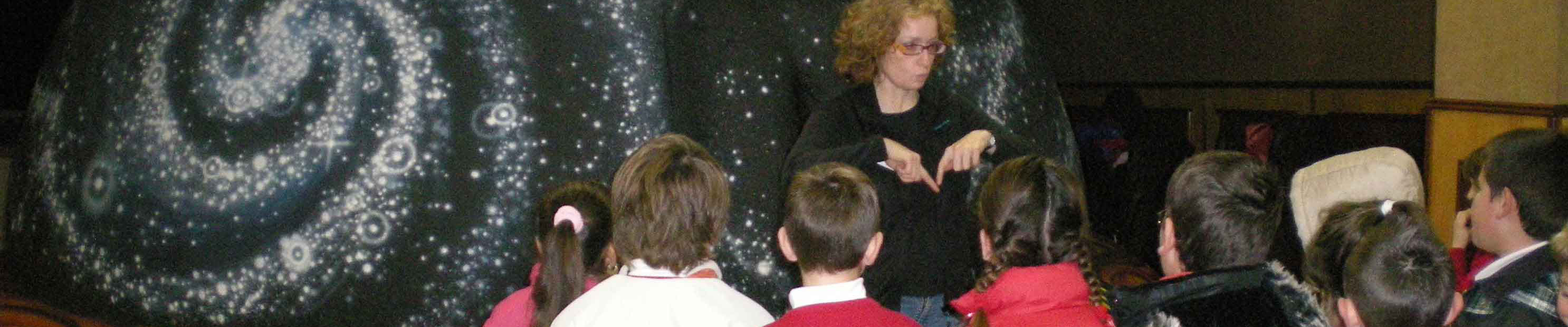 Niños disfrutando de una presentación en un planetario móvil para colegios, aprendiendo sobre la observación de estrellas y el universo. Esta actividad es ideal para talleres infantiles planetario.